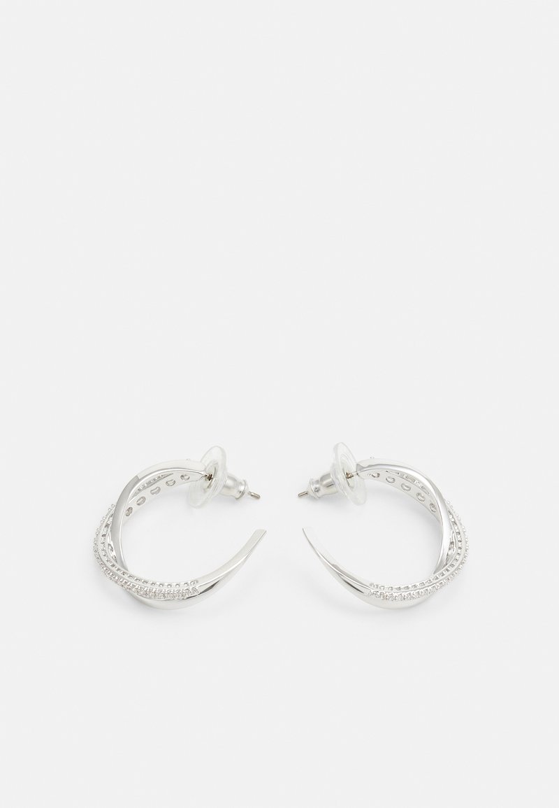 Silvriga hoopsörhängen med en böjd design och texturerad yta, prydda med små dekorativa stenar längs ena sidan.