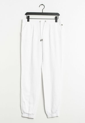 White jogger pants made of soft fabric, featuring an elastic waistband, drawstring, two side pockets, and tapered cuffs.