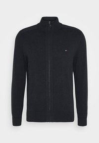 Herenvest met rits in donkergrijs, gemaakt van gebreide stof. Heeft een hoge kraag en geribbelde manchetten. Klein logo op de linkerborst.