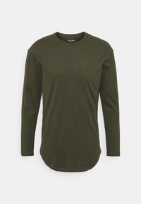 Långärmad t-shirt i mörkgrön, tillverkad av bomull. Har en rundad halsringning och en rundad nederkant för en något förlängd silhuett.