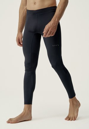 Leggings sportivi blu navy realizzati in tessuto elasticizzato, con una texture liscia, design aderente e dettagli di cucitura minimi.