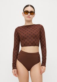 Brauner langärmeliger Crop-Top mit dunklem Blumenmuster, kombiniert mit hochgeschnittenen braunen Bikini-Hosen, glatte Textur, enganliegendes Design.