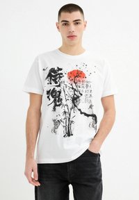 Camiseta de algodón blanca con estampado gráfico en negro y rojo de bambú, árboles y caracteres japoneses. Diseño clásico de cuello redondo.