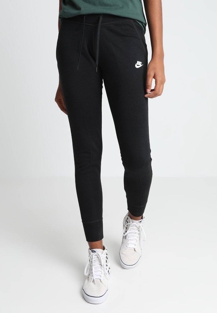 Svarta tapered sweatpants med elastiska muddar, dragsko i midjan och en liten vit Nike-logga på vänster lår. Material av bomullsblandning.