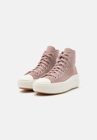 Zapatillas altas de ante suave en rosa claro con punteras de goma blanca y suelas gruesas. Presentan ojales de metal y un panel lateral texturizado.