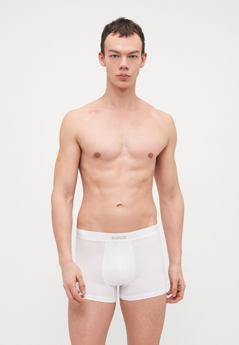 Weiße Baumwollboxershorts mit elastischem Bund, auf dem das Logo "SLOGGI" aufgedruckt ist. Glatte Textur, enge Passform und mittellanger Schnitt.
