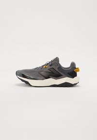 Chaussure de sport grise avec une tige en maille, des accents noirs, des détails réfléchissants et une épaisse semelle blanche avec une semelle extérieure noire texturée.