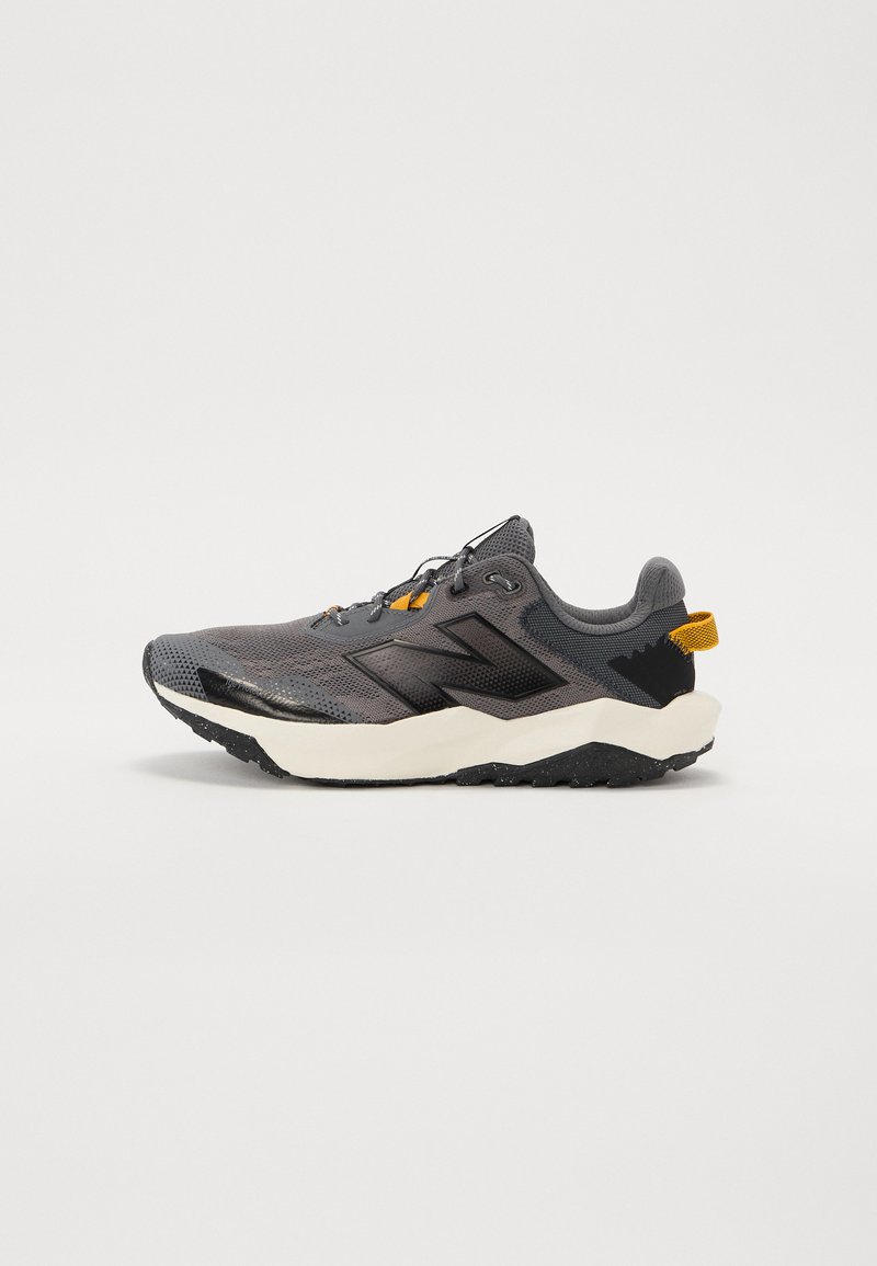 Chaussure de sport grise avec une tige en maille, des accents noirs, des détails réfléchissants et une épaisse semelle blanche avec une semelle extérieure noire texturée.
