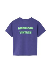 T-shirt à manches courtes violet avec un texte vert audacieux disant "AMERICAN VINTAGE" centré au dos.