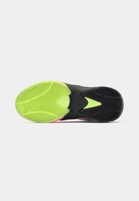 Suela de zapatilla deportiva con una vibrante parte inferior de goma verde, patrón texturizado, entresuela negra y acentos en rosa y amarillo.