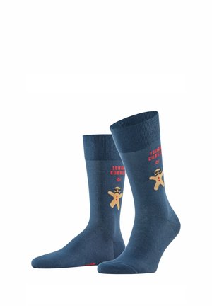 Chaussettes en coton bleu avec un graphisme de bonhomme en pain d'épice portant des lunettes de soleil, accompagné du texte « TOUGH COOKIE » au-dessus. Design classique avec un ourlet côtelé.