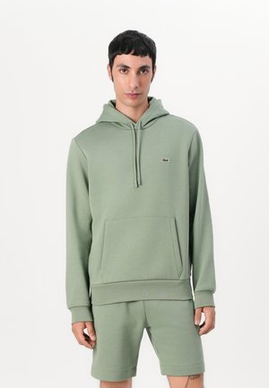 Lichtgroene hoodie met een voorzak en een capuchon met trekkoord, gecombineerd met bijpassende shorts. Gemaakt van zacht, gestructureerd materiaal en voorzien van een logo-accent.