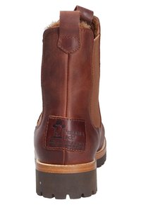 Botín de cuero marrón hasta el tobillo con punta redonda, lengüeta y parche de logo en la parte trasera. Presenta una suela texturizada para mayor tracción.