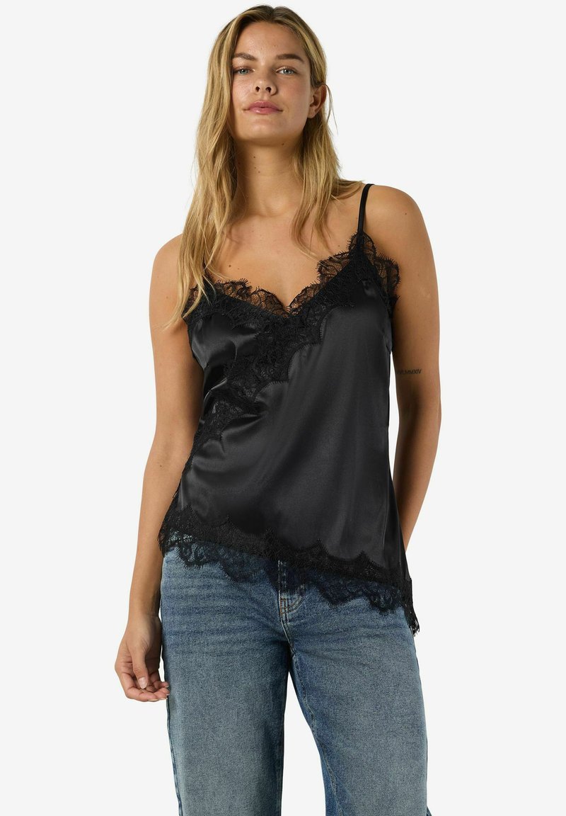 Mustast satiinist kamisol pitsist ääristusega kaelusel ja hemil. Õhukesed reguleeritavad rihmad ja lõdvestunud lõige. Kandmiseks koos siniste teksadega.