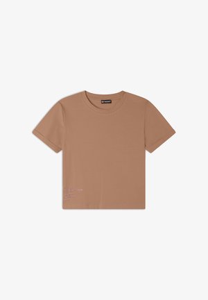 Camiseta de manga corta marrón en tejido suave, con un escote redondo y un pequeño detalle de texto en blanco en la esquina inferior izquierda.