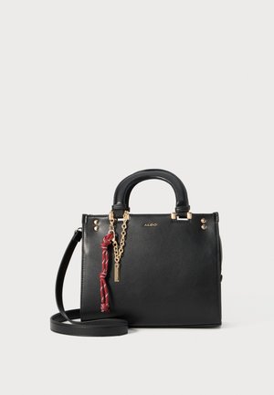Black leather handbag with dual handles, detachable crossbody strap, gold hardware, and a red tassel detail. Simple design with gold accents.