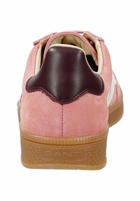 Zapatilla deportiva de ante rosa con un acento en el talón de cuero burdeos, forro beige y suela de goma beige texturizada. Presenta un diseño de talón ondulado.