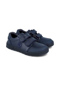 Zapatillas infantiles de color azul marino hechas de cuero suave. Cuentan con dos correas de velcro y una suela de goma texturizada. Detalle de logo bordado.