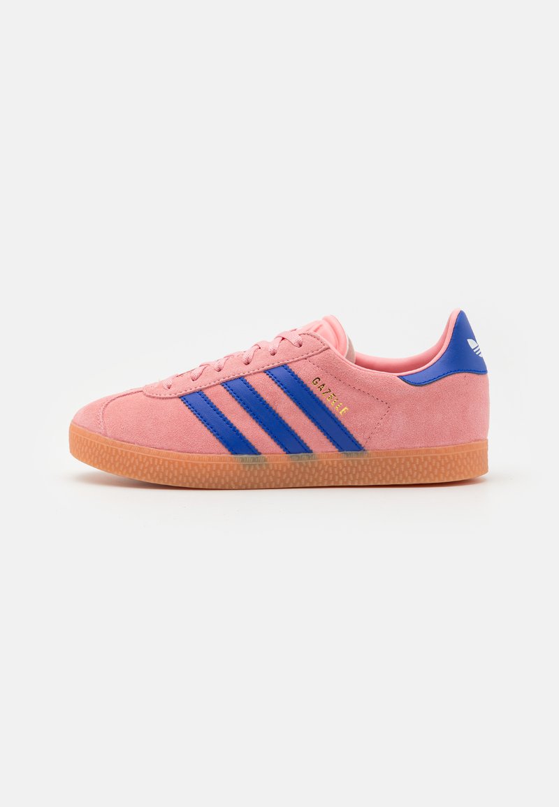 Rosa semskede sneakers med tre blå striper, såle av teksturert gummi, og en blå accent på hælen. "Gazelle"-logo på siden.
