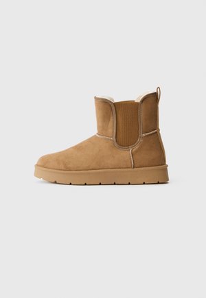 Mid-height tan suede boot with elastic side panels, rubber sole, pull tab, and soft, light-colored inner lining.