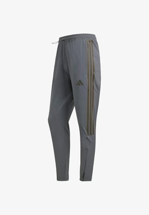 Szare sportowe spodnie z elastycznym pasem, z trzema kontrastującymi ciemnymi paskami po bokach i zamkiem przy kostce.