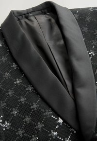 Fekete flitteres nadrágöltöny dzseki, selyem bársonykollárral, bonyolult mintázattal az anyagon és sima bélésel.