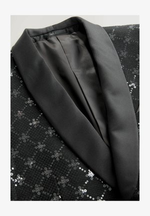 Svart paljett-tuxedojacka med satin-sjökrage, intrikat mönster på tyget och slät innersöm.