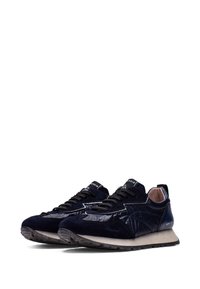 Baskets bleu marine mêlant suède et matière brillante. Elles sont dotées de lacets et d'une semelle texturée, avec un logo sur la languette et le talon.