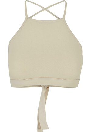 Beige halter stila crop tops, kas izgatavots no gludas auduma. Iespējo krustveida siksnas un sasienama aizmugures detaļa, lai pielāgotu fit.