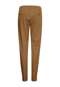 Brune, tapered bukser med en blød tekstur, elastisk talje og to baglommer. Designet har en glat overflade uden synlige sømme.