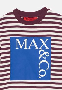 Stripet t-skjorte i maroon og hvite farger, med en blå firkant som har hvit tekst "MAX&Co." på forsiden. Rund hals, laget av bomull.