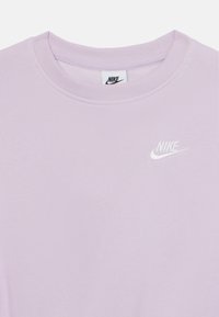 Svijetloplavi Nike dukserica s okruglim izrezom, rebrastim manžetama i malim bijelim logom na prsima. Mekani tekstil.