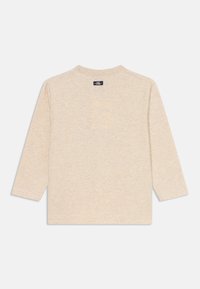 Beige Langarmhemd aus weichem Stoff mit Rundhalsausschnitt und legerer Passform. Label hinten am Nacken sichtbar. Keine ausgeprägten Muster.