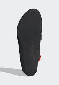 Schwarze Kletterschuhsohle mit einer glatten, flachen Oberfläche und einer leichten Krümmung. Verfügt über eine kontrastierende orangefarbene Fersenschlaufe an der Seite.