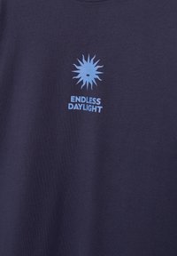Tissu bleu marine avec un graphisme stylisé de soleil bleu clair au-dessus du texte « ENDLESS DAYLIGHT » en lettres majuscules en gras.