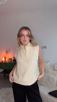 Haut sans manches en maille côtelée couleur crème avec un col à fermeture éclair, coupe décontractée, associé à un pantalon ample noir. Design simple et texturé sans motifs.