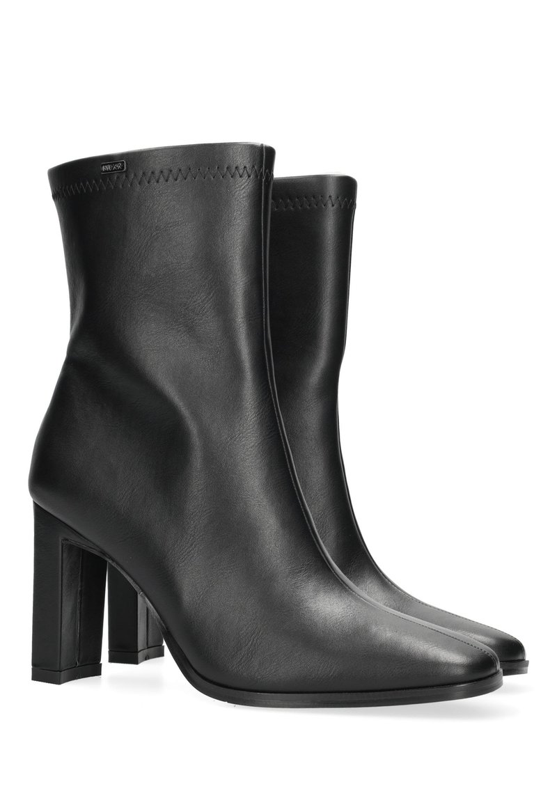 Czarne skórzane botki za kostkę o eleganckim fasonie, szpiczastych noskach i wysokim, masywnym obcasie. Wykończone przeszyciem wzdłuż górnej krawędzi.