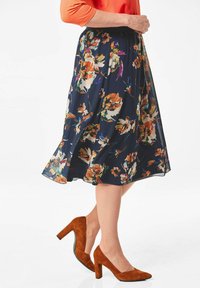 Navy bloemen midi rok met meerkleurige bloemen; lichte stof; uitlopende vorm; gecombineerd met bruin suède hoge hakken.