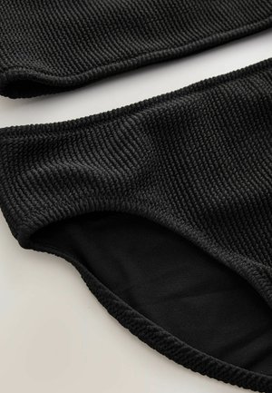Schwarzes Bikini-Set aus strukturiertem Rippstoff. Das Oberteil hat ein breites Band; das Unterteil hat ein glattes Innenfutter und elastische Kanten.