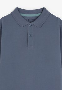 Polo de algodón en azul oscuro. Presenta un cuello clásico, una tapeta de dos botones y una tela texturizada con un acabado sutil de canalé.