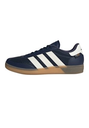 Marineblå og hvid lavtop-sneaker med gum-sål, hvide tre striber på siden og Cordura-stofmærke nær hælen.