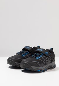 Schwarze Sportschuhe mit Mesh-Einsätzen, blauen Akzenten und strukturierten Sohlen. Ausgestattet mit Schnürsenkeln und einem Klettverschluss für sicheren Sitz. Leichtes Design.