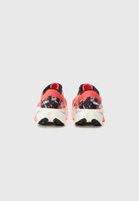 Rote und schwarze Sportschuhe mit strukturiertem Obermaterial, kontrastierender Ferse und Sohle, ausgestattet mit Logodetails und schrägen Designelementen.