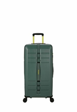 Valise rigide de couleur vert mat, avec une surface texturée, une poignée rétractable jaune et des roues multidirectionnelles pour une maniabilité aisée.