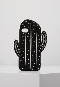 Coque de téléphone en silicone noir en forme de cactus, avec des lignes verticales blanches et de petits motifs de feuilles sur une surface texturée.