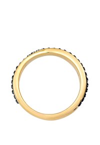 Anillo de oro con una banda lisa y una fila de gemas negras alrededor del borde exterior, creando un contraste texturizado en una superficie pulida.