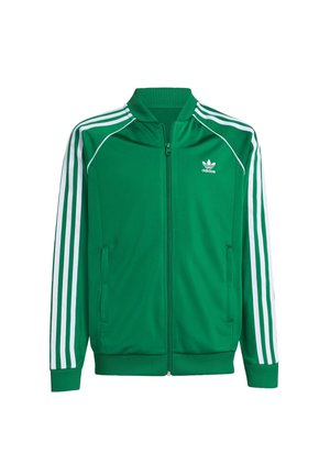 Veste de survêtement à fermeture éclair Adidas verte avec détails à trois bandes blanches sur les manches et logo Adidas sur le côté gauche de la poitrine.