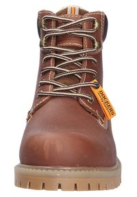Bottines de travail en cuir marron avec un bout rond, des lacets noir et blanc, une étiquette logo jaune et une semelle en caoutchouc texturée. Construction durable avec des détails de couture.