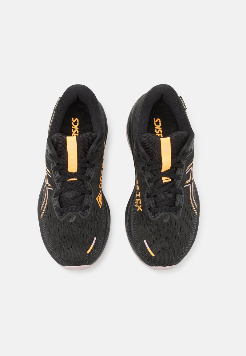 Chaussures de sport noires avec une tige en mesh texturée, des accents orange et des détails réfléchissants ; dotées d'une semelle rembourrée et d'un système de laçage.