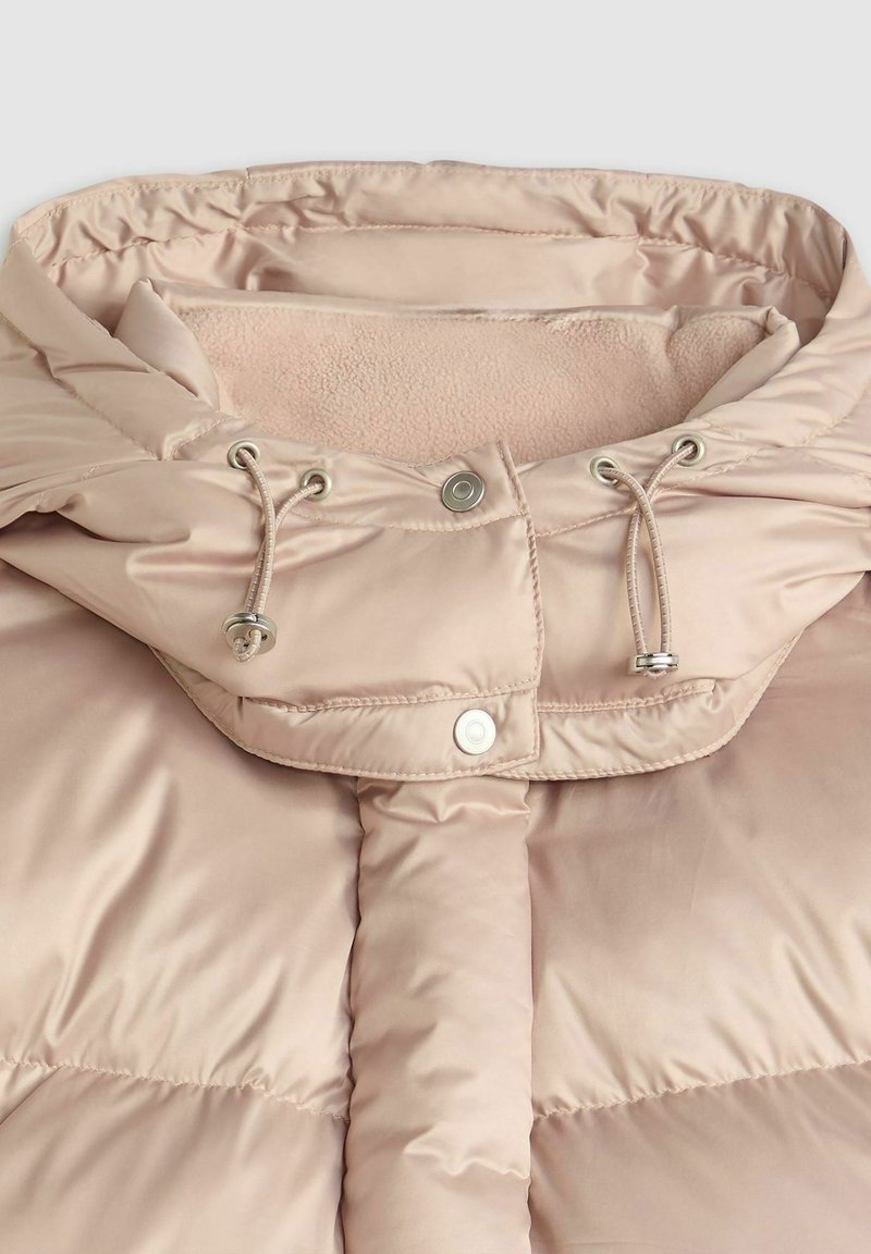 Chaqueta acolchada de color rosa claro con capucha forrada de suave polar, cordones ajustables y cierres a presión. Tela lisa y brillante con textura acolchada.